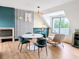 a living room with a table and chairs and a fireplace at Hotel Ker Vennaik in Bénodet