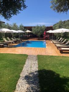 a swimming pool with chairs and umbrellas at Obelix Bungalows in Fethiye