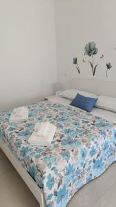 a bed in a room with a blue and white blanket at Dimora L&A in Portocannone