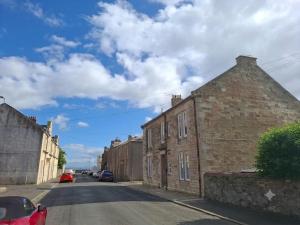 an old brick building on the side of a street at Dunes Apartment Troon in Troon