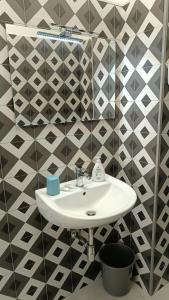 a white sink in a bathroom with black and white tiles at Dimora L&A in Portocannone