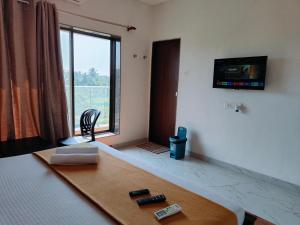 a room with a bed with a television on the wall at Shiv Shakti in Alibaug