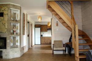 a living room with a staircase and a kitchen at Leśny Dworek 1 in Wołkowyja
