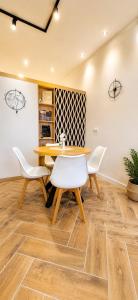 a dining room with a table and white chairs at Apartman Aurelia in Sremska Mitrovica