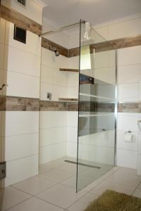 a glass shower in a bathroom with white tiles at Leśny Dworek 1 in Wołkowyja +39 photos