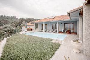 a villa with a swimming pool and a house at Casa Fregim in Amarante
