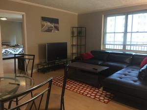 sala de estar con sofá negro y mesa de cristal en Downtown Big 1 Bedroom #20I, en Atlanta