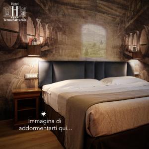a bedroom with a large bed with a painting on the wall at Hotel Terme Salvarola in Sassuolo