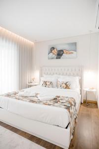 a white bedroom with a large bed with white sheets and pillows at Casa Fregim in Amarante +64 photos