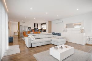 a living room with a white couch and a table at Casa Fregim in Amarante