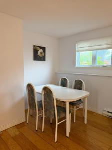 a dining room table with four chairs around it at Urban Midtown Stays in St. John's