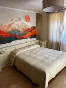 a bedroom with a large bed with a painting on the wall at Hotel Bucaneve in Bardonecchia