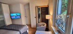 a hotel room with a bed and a tv on the wall at Gästezimmer Hönow bei Berlin in Hoppegarten +12 photos