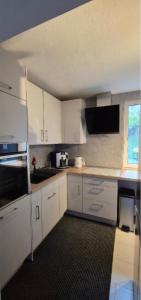 a kitchen with white cabinets and a black rug at Gästezimmer Hönow bei Berlin in Hoppegarten