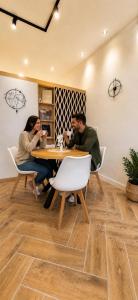 two people sitting at a table in a room at Apartman Aurelia in Sremska Mitrovica +16 photos
