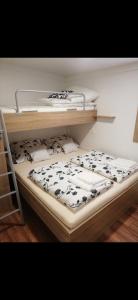 a bunk bed with black and white sheets and pillows at MOBILE HOME Nikol in Pirovac +19 photos