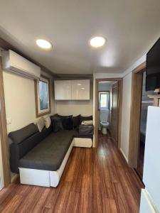 a living room with a couch in a tiny house at MOBILE HOME Nikol in Pirovac
