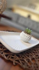a small pineapple on a white plate on a table at Square View Apartment Center Niksic in Nikšić +22 photos