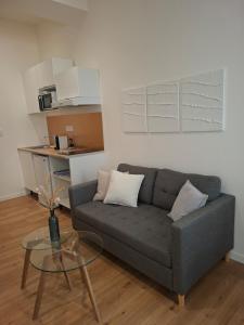 a living room with a couch and a glass table at Studio lumineux - 1er étage - Centre Vienne in Vienne