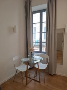 a table and chairs in a room with a window at Studio lumineux - 1er étage - Centre Vienne in Vienne