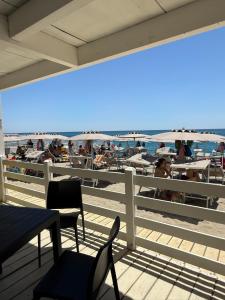 a deck with chairs and people on the beach at Chalet n5- Ombrellone GRATIS incluso a Catanzaro Lido- in Catanzaro