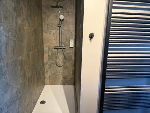 a bathroom with a shower with a glass door at Balcony by Giorgi - Centre de Bastogne in Bastogne