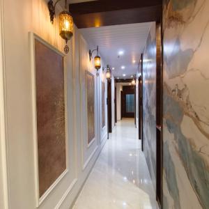a hallway with white floors and paintings on the walls at Mi Residency Lodging & Boarding in Thane