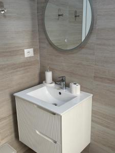a bathroom with a white sink and a mirror at Koko Pepito apartment in Lezhë