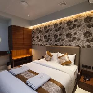 a hotel room with two beds and a bench at Mi Residency Lodging & Boarding in Thane