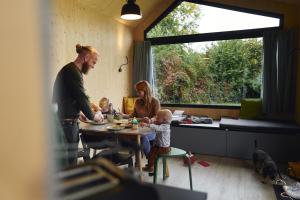 a family sitting at a table with their babies at Wellnester Tiny Houses in Losheim am See in Losheim
