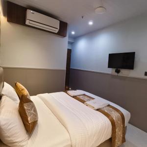 a hotel room with a bed and a flat screen tv at Mi Residency Lodging & Boarding in Thane