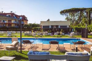 a pool with chairs and tables and a building at Casale Incanto in Terracina