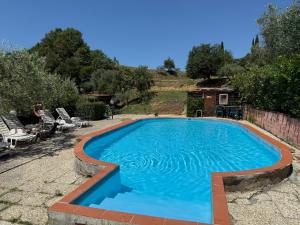 a swimming pool with blue water in a yard at Tenuta Selvaggia in Reggello