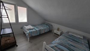 a attic bedroom with two beds and a ladder at Square View Apartment Center Niksic in Nikšić