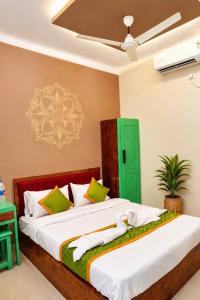 a bedroom with two beds and a green door at Levora Suits in Kottayam