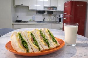 a sandwich on a plate next to a glass of milk at MAMA Alice in Seoul