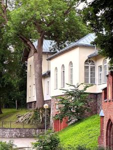 a white house with a tree in front of it at Cathedral Apartment Tartu in Tartu