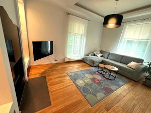a living room with a couch and a flat screen tv at Cathedral Apartment Tartu in Tartu