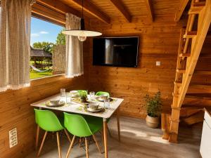 a dining room with a table and green chairs at Domki Nad Morzem Sobiescy in Stegna +9 photos
