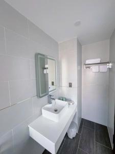 a white bathroom with a sink and a mirror at Bay Homestay in Cam Lâm +50 photos
