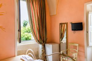 a room with orange walls and a mirror and a window at Tenuta Masseria del Gallo in Calimera