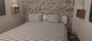 a bed with two striped pillows in a bedroom at Votre terrasse vue mer sous la vigne, un havre de paix in Ensuès-la-Redonne