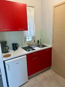a kitchen with red cabinets and a sink at Glikis ear apartments in Gliki