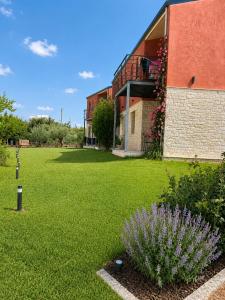 a building with a green yard with a plant at Glikis ear apartments in Gliki