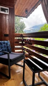 a chair and a bench on a porch with a view at Apartments Gabliani in Mestia in Mestia