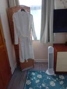 a robe hanging in a room with a window at Owls Roost in Stowmarket