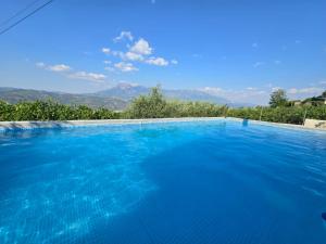 a large blue swimming pool with mountains in the background at Swimming Pool - Valley View Home Drobonik in Drobonik