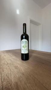 a bottle of wine sitting on a wooden table at Bujtina Dalmacia 2 in Shkodër