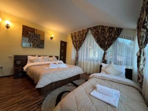 a hotel room with two beds with towels on them at Pensiunea Un colț de Rai in Lunca Jariştei +48 photos