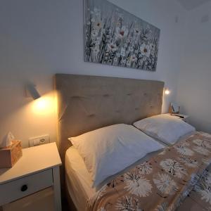 a bed in a bedroom with a picture on the wall at Room Mate in Malinska